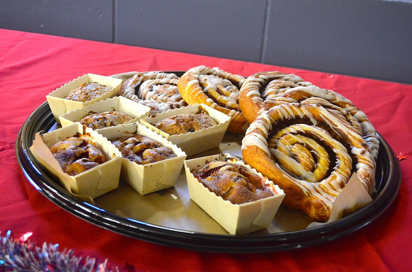 Cinnamon rolls and other breakfast items line tables in the cafeteria.