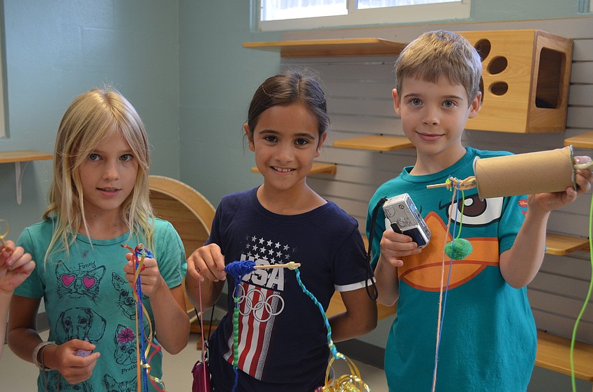 Sydney Andrews, Savannah Sherindan and Cole Laudenslager show off the cat toys they made.