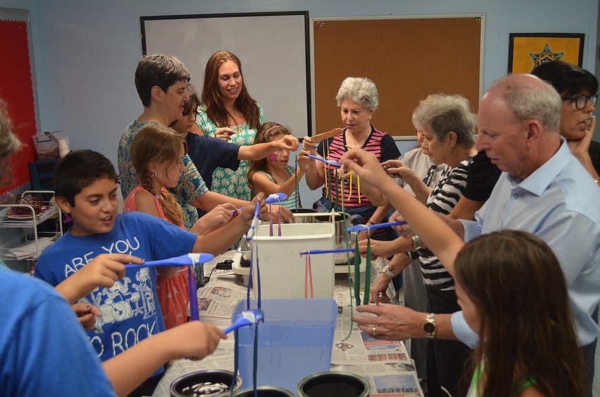 The group make the candles in the templeâ€™s religious school.