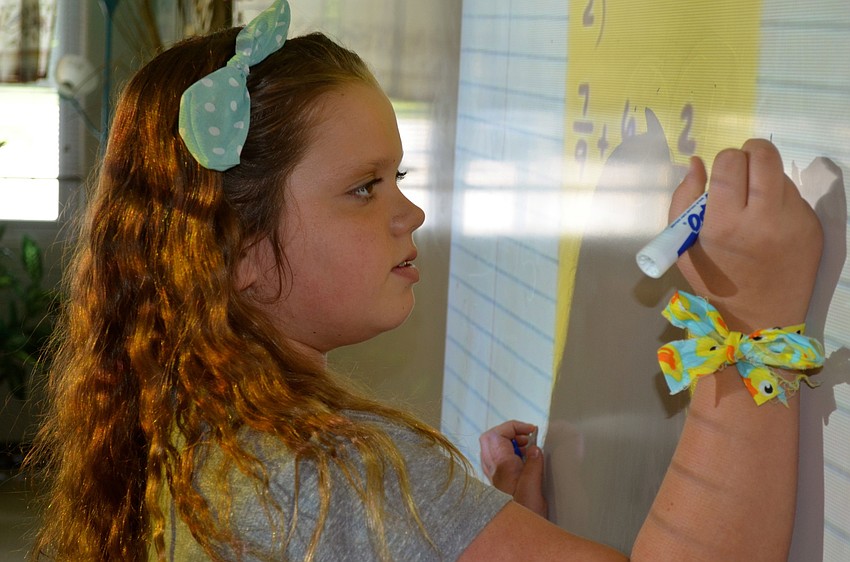 Jordan Eollinger solves an equation on the board.