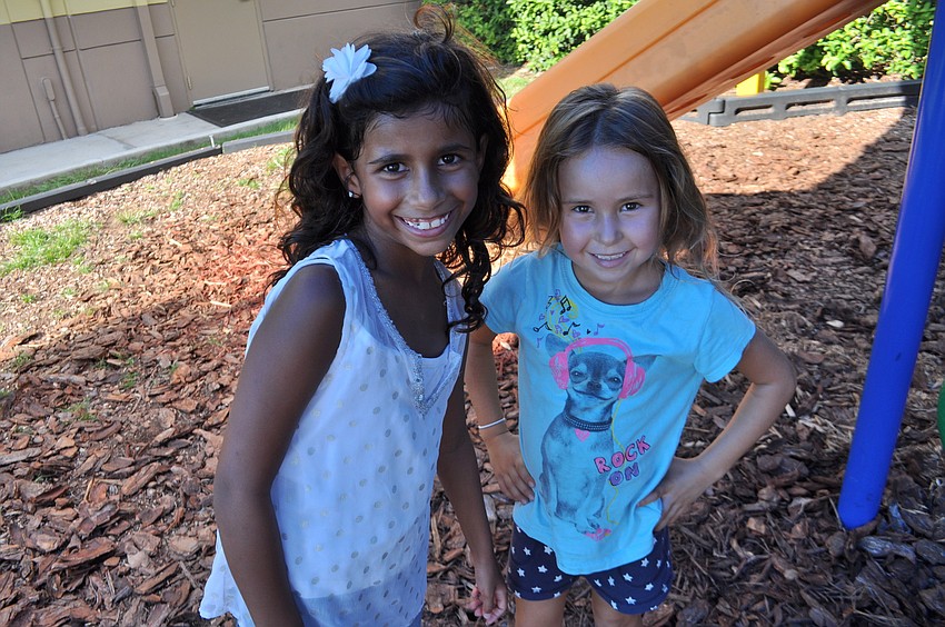Victoria Somaroo and Nataly Gina play on the playground.