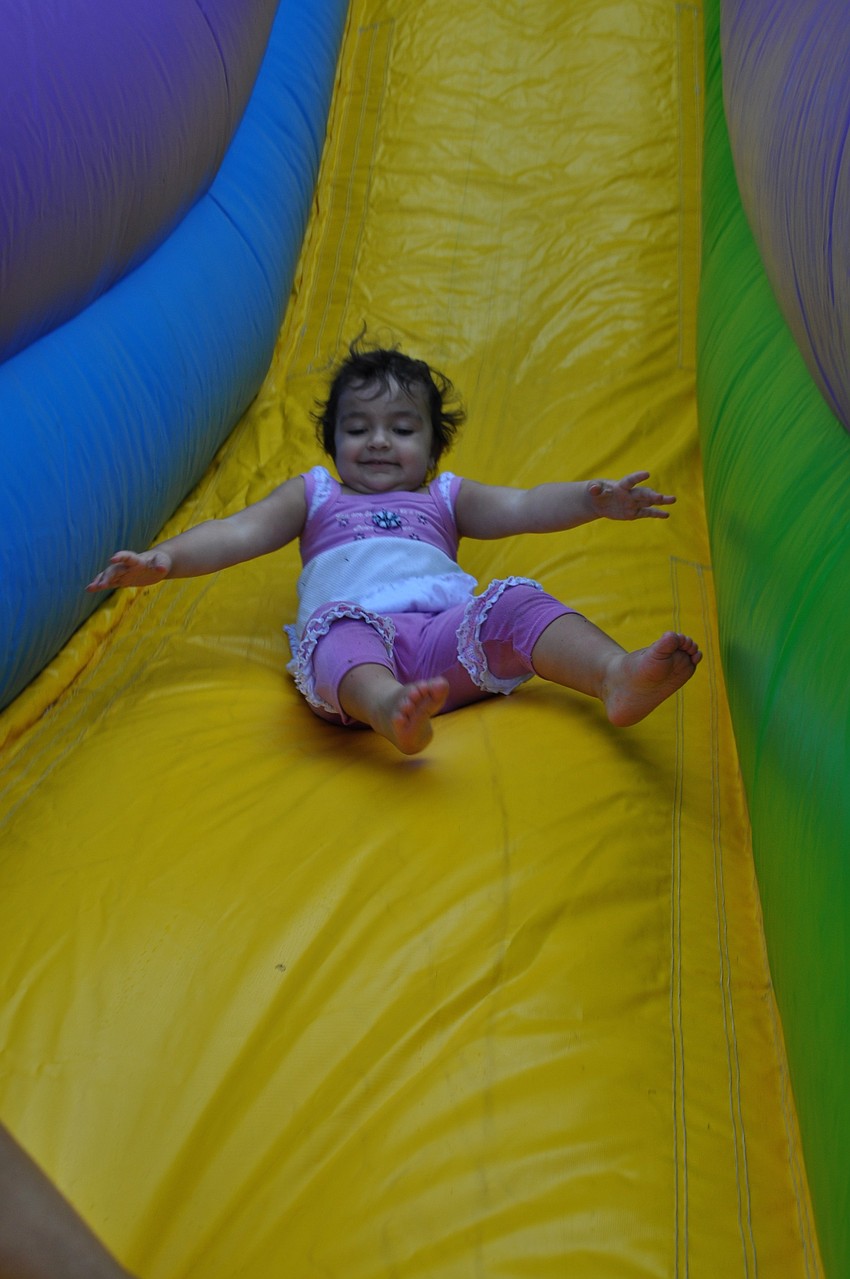 Sophie Rivers, 2, goes down an inflatable slide.