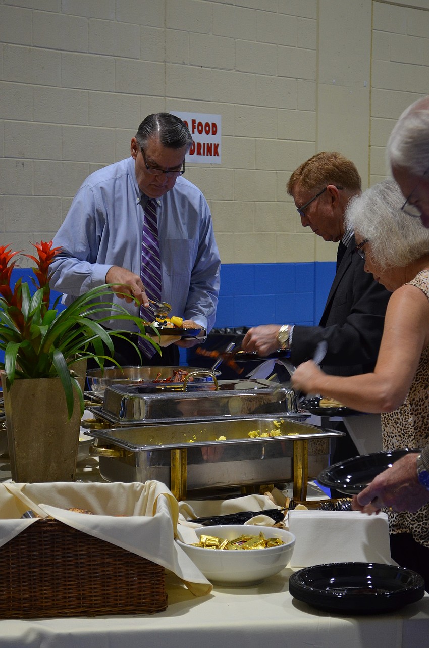 Attendees serve themselves before sitting down for the presentation.