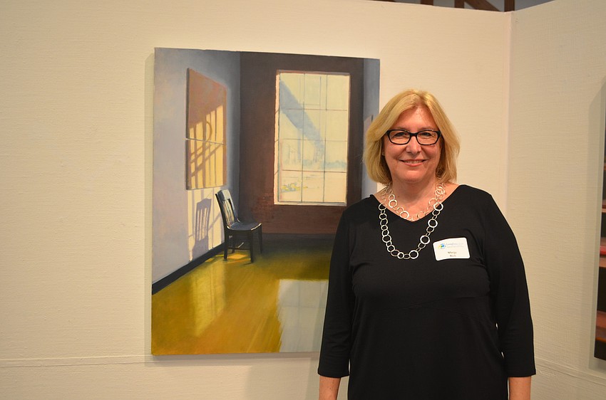 Margy Rich poses in front of her painting â€œNPQ.â€