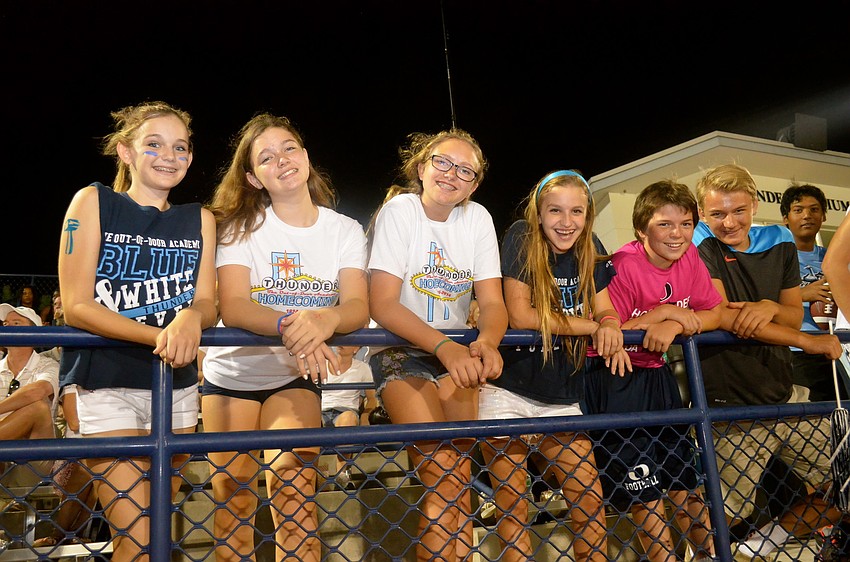 Gracie Schlotthauer, Kinsey Newhams, Celia Miller, Natalya Laliberty, Declan McCann and Filip Sawyer cheer from the fence.