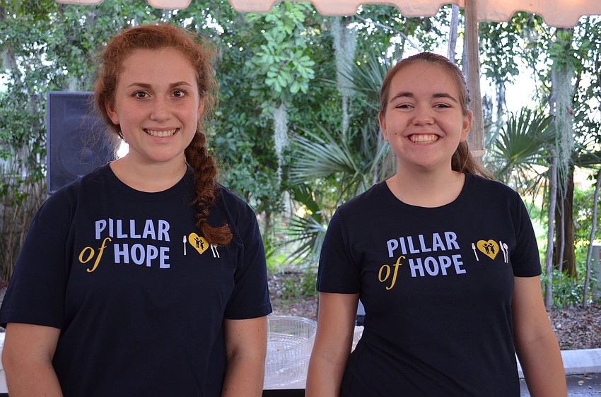 Emma Knego and Katie Green volunteer at the Pillar for Hope open house at the Child Protection Center Thursday night.
