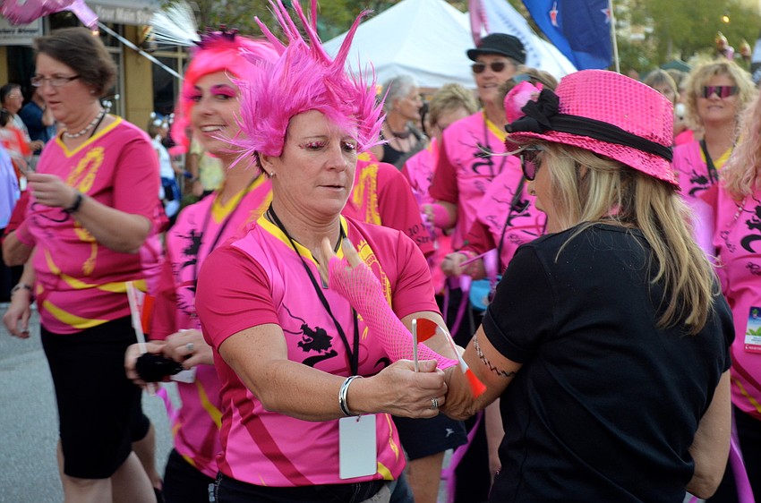 Women from opposing teams give each other keepsakes during the parade.