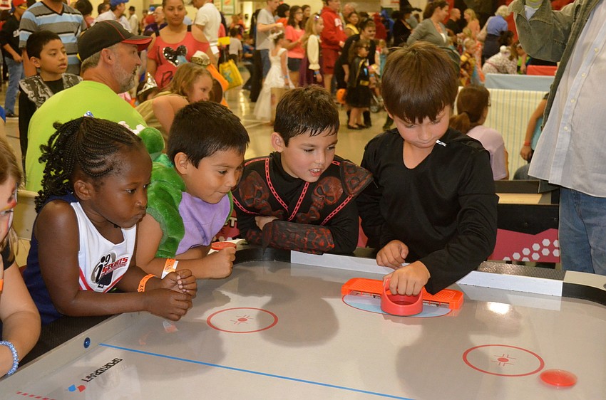 Children play air hockey and other games at the festival.