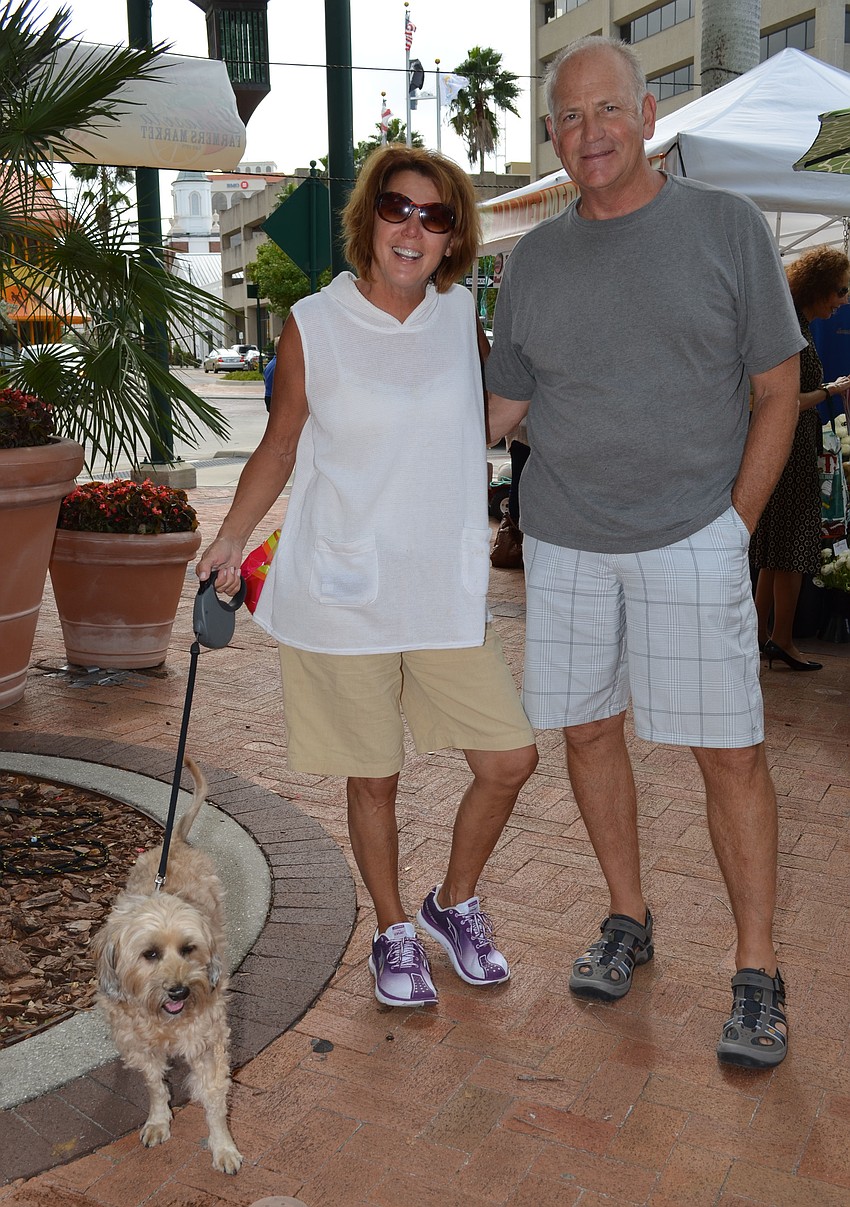 Eileen Koutelas, Scott Courtney and Scooter walk through the Downtown Farmers Market.