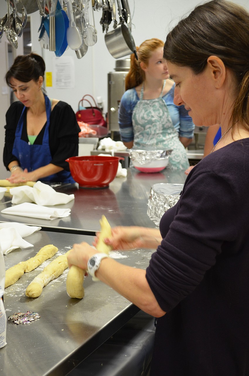 Rabbi Elaine Glickman demonstrates how to braid a challah bread.