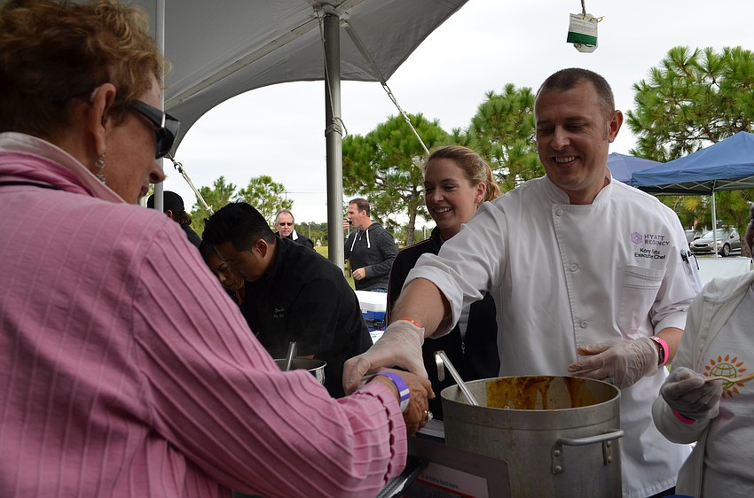 Maureen Binderman is served roasted sweet potato soupe with curried apple compote by Kory Foltz from the Hyatt Regency.