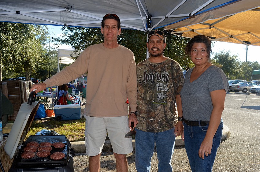 Colin Campbell poses with Ed and TIna Gonzalez after grilling burgers. Team members Tami and Cami Campbell not pictured.