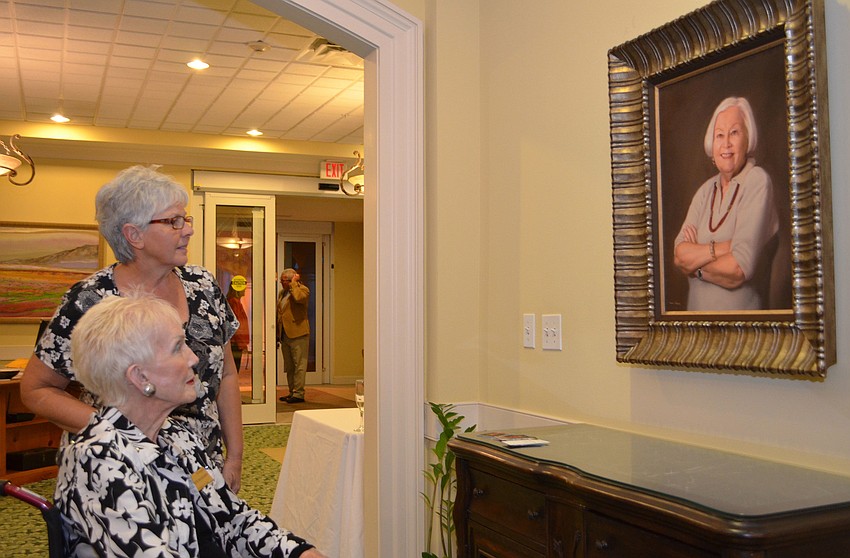 Mary Louise Raber and Dottie Oehlschlaeger admire the portrait of Mary Fran Carroll.