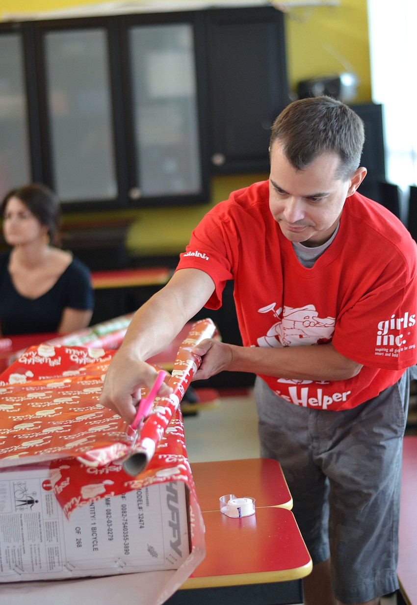 YPG member Joel Marra gift wraps toys at Girls Inc.