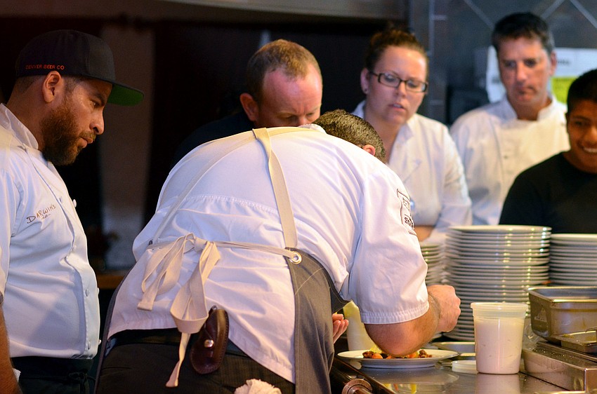Chefs watch as Chef Paul Anders puts the final touches on his first course.