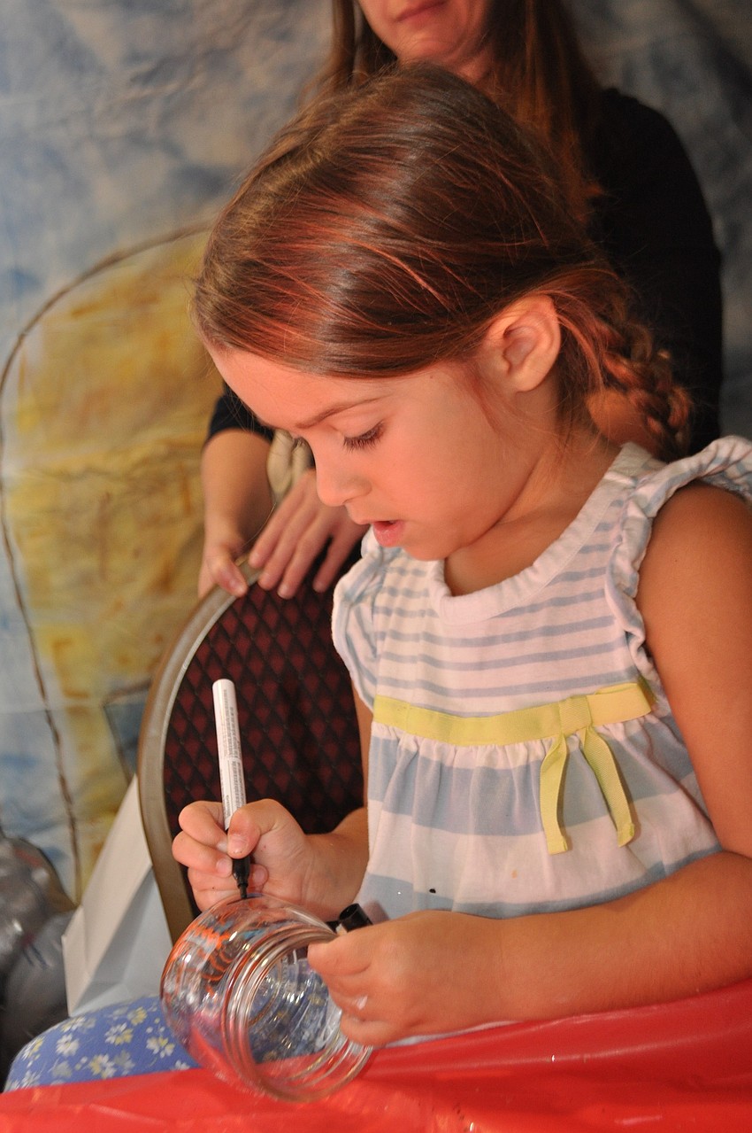 Abigail Cobb, 4, decorates a glass container.