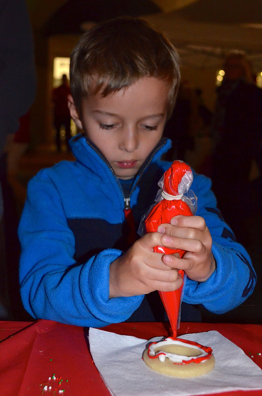 Seven-year-old Matthew Ray decorates a cookie at The Observer's booth.