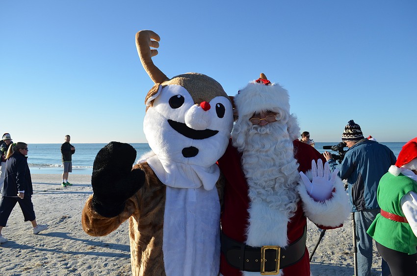 Rudolph the red-nosed reindeer and Santa Claus wave off runners at the start of the 5K.