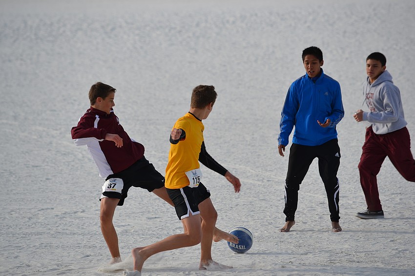 Members of the Riverview High School soccer team play a pick-up game on Siesta Beach.