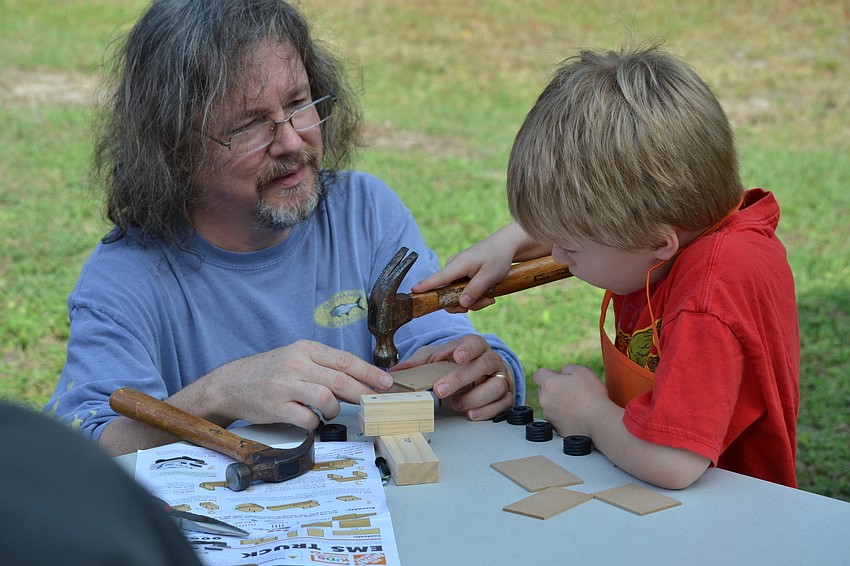 Brian Gomien helps his son Rory build an EMS truck provided by the Home Depot.