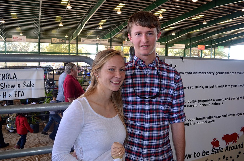 Heather Payne and Colton Stanton watch the animal sale from the sidelines.
