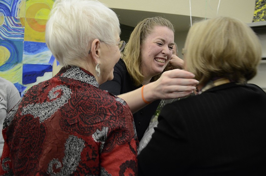 Christi McDowell-Cameron hugs Caroline Zucker and Shirley Brown after being surprised with the Middle School Teacher of the Year Award.