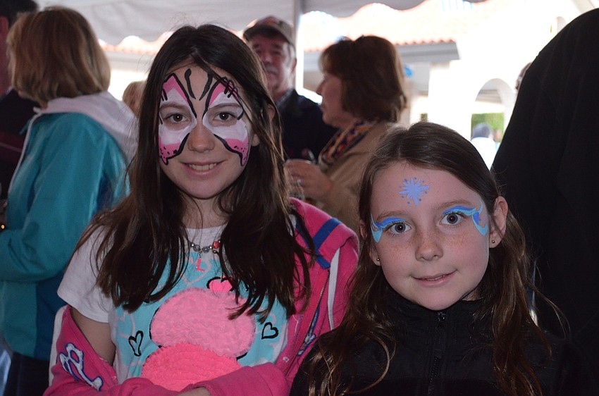 Sisters Lillian and Josie Paisley wear matching smiles on their painted faces.