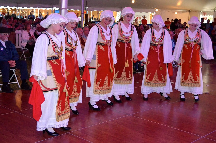 There are six girls in the Hellenic folk dancing group.
