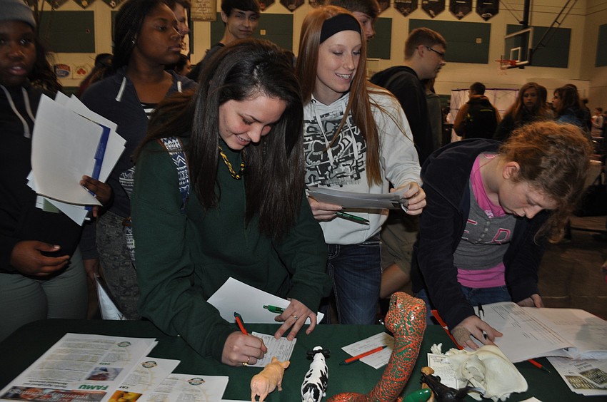 Hailey Barns fills out a card for Florida Agricultural and Mechanical University.