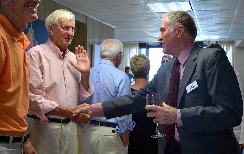 Lou Newman greets attendees as they enter the gallery.