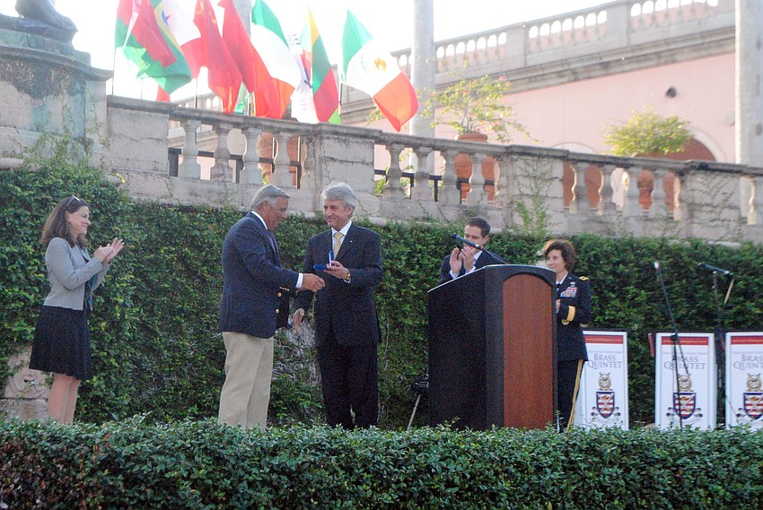 The son of honoree Col. John Russell accepts the Baron de Coubertin Medal of Honor from UIPM President Dr. H. C. Klaus Schormann.