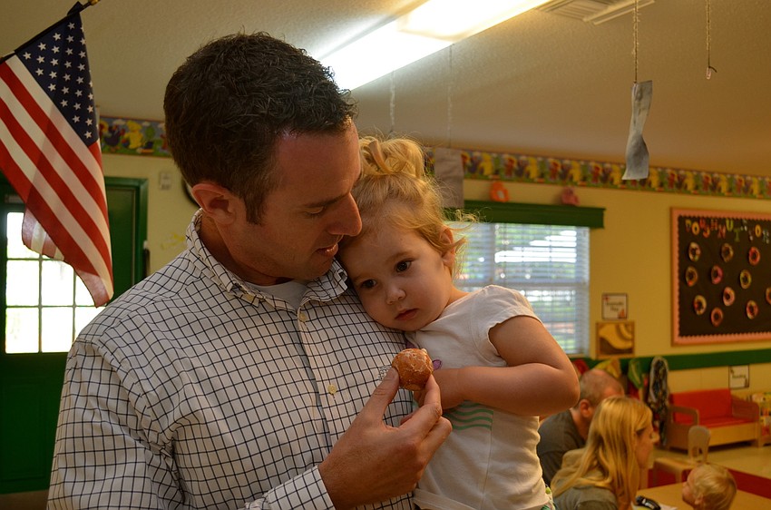 Wes Miller tries to persuade his daughter, Claire, to eat a donut.