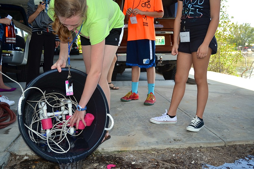 Instructor April Arbogast rinses off the campâ€™s robot, RV Seaweed, after itâ€™s practice run in the pool. Later in the week, the campers and RV Seaweed may get to test the waters of the Bay.
