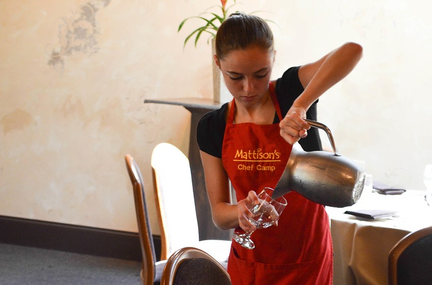 Kendall Peacock pours glasses of water for the parents