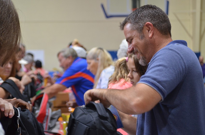 Kevin Greene helps fill backpacks.