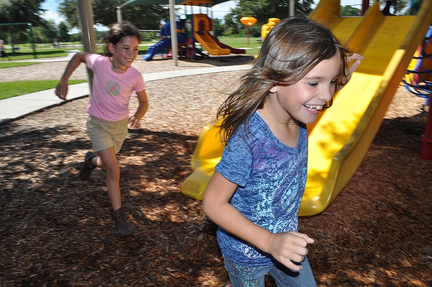 Lily Lawrence, 8, runs from her new friend, Macayla Yannucciello, left, in a game of tag.