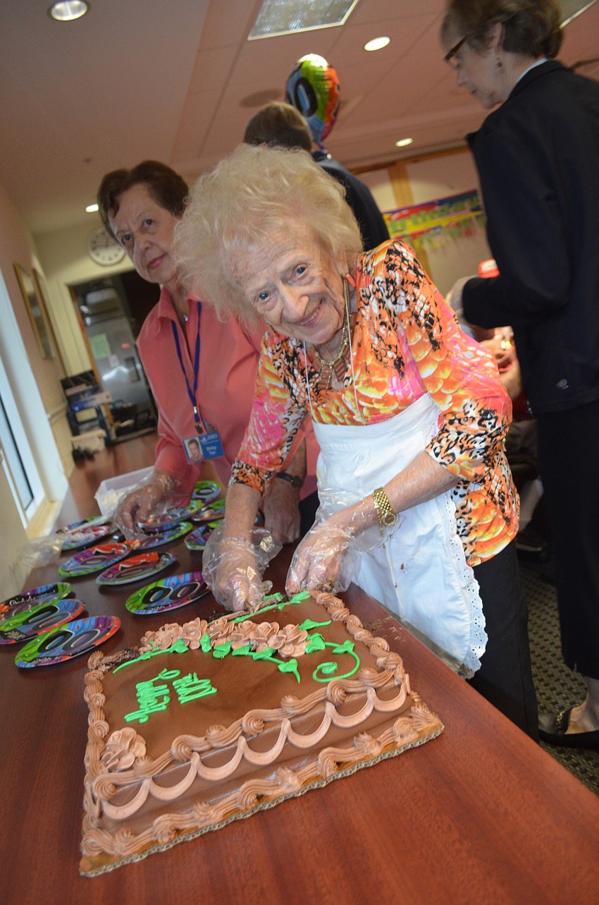 Flo Katz, 99, cuts Carson's cake.