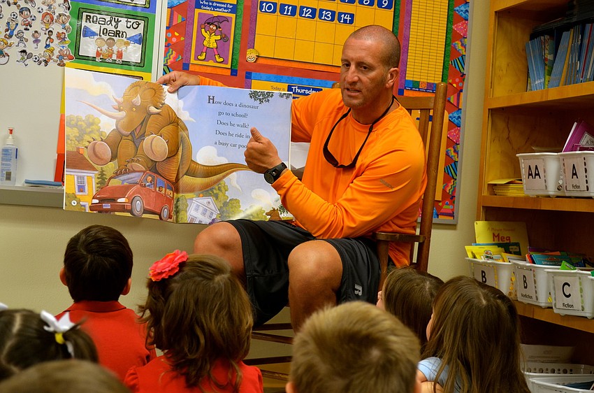 Physical Education teacher Eric Boso reads a story to children on the first day of school.