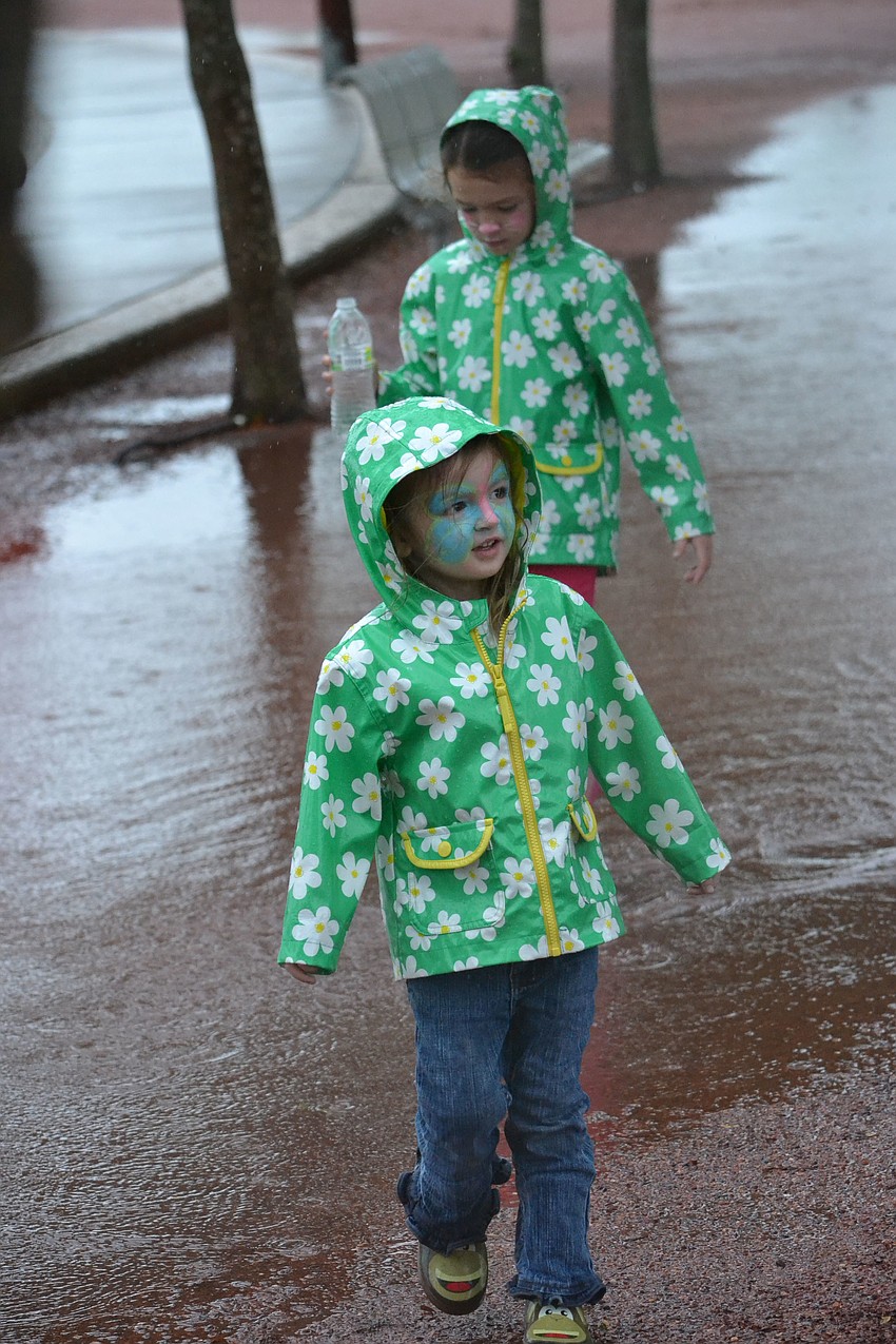 Kendall, 3 and Leah, 7, take a break from walking to play in the puddles on the track.