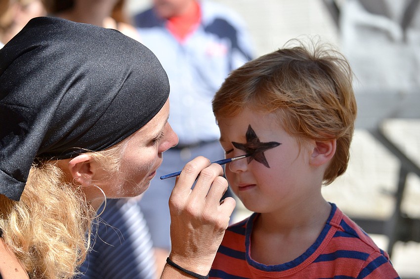 Rowan Callaway gets his face painted like a member of the band KISS.