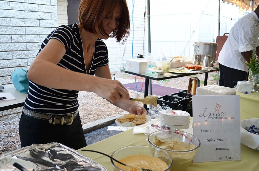 Gena Marini prepares a sample plate of hummus.