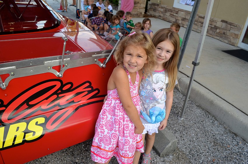Claire Freund and Avery Clough are intrigued by the race car.