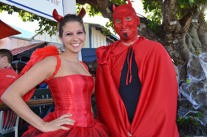 Samantha Lemmer and Phil Resler hand out candy to children in Siesta Key Village.