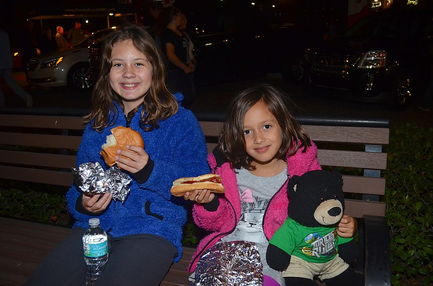 Abigail and Stefani Sweitzer snack on hot dogs.