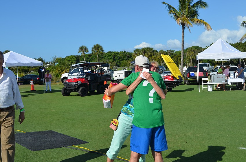 Holly Baran hugs Michael Ganey after winning the raffleâ€™s second prize, â€œA Year of Delicious Dining.â€