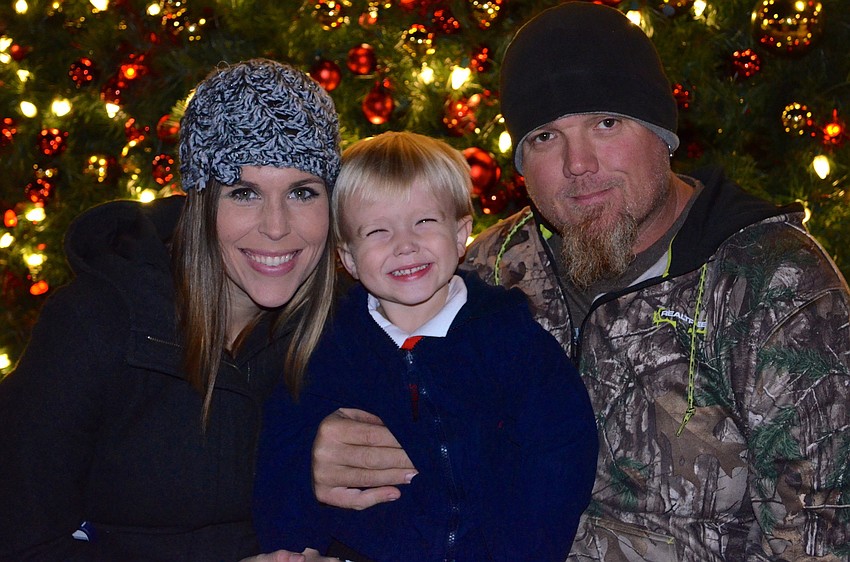 The Noble family â€” Lindsay, Brody and Tony â€” find a spot near the freshly lit tree.