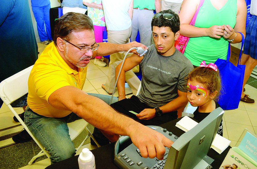 Dr. William Bennett explains an ultrasound to Armando Quiroz during Lakewood Ranch Medical Center and Lakewood Ranch Community Activities' health and wellness expo, which celebrated the hospital's 10th anniversary.