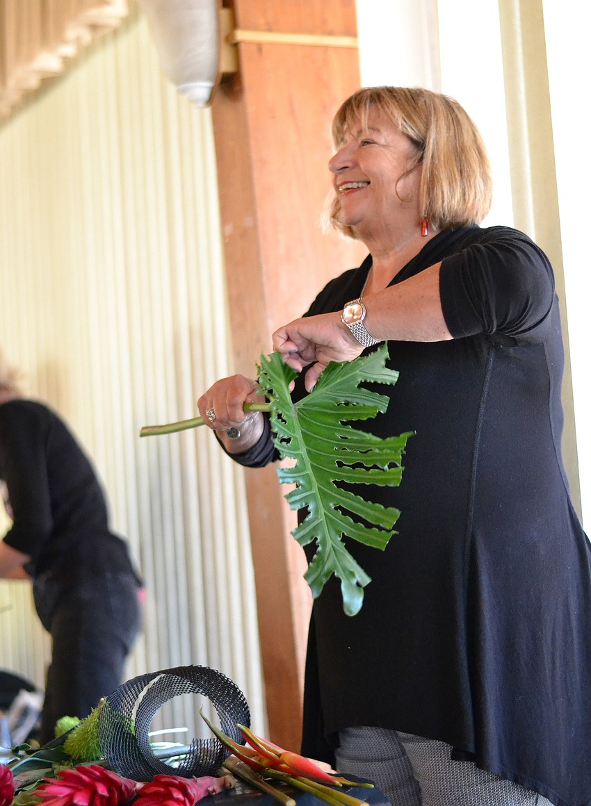 Barbara Roa bends a branch of fox tail for her floral arrangement.