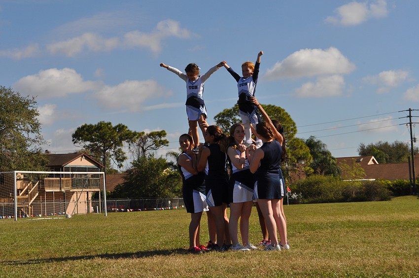 Cheerleaders and mascots perform a cheer.