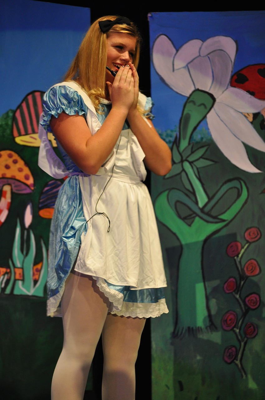 Taylor Woodring, as a giant Alice, sobs after she eats a cookie and grows too large.